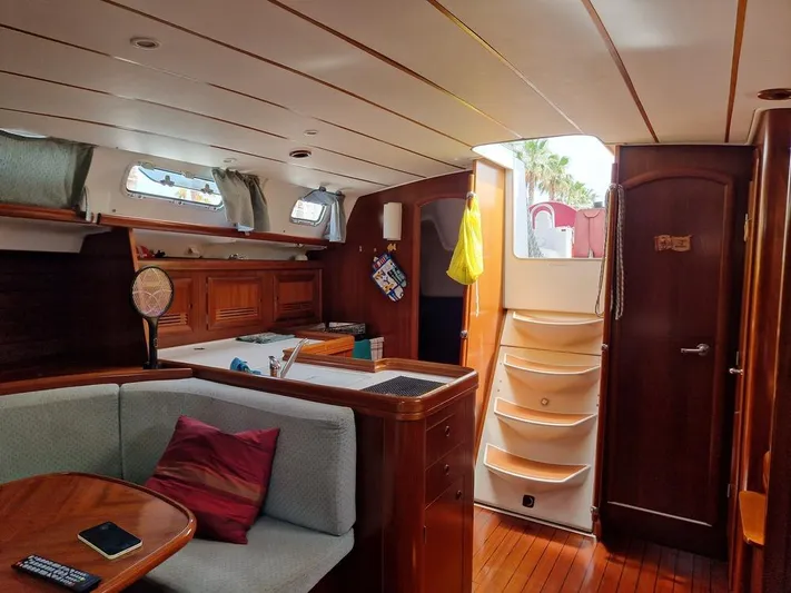  Yacht Photos Pics Interior of 2001 Beneteau Oceanis 473 Clipper sailboat, featuring cozy seating and wooden finishes.