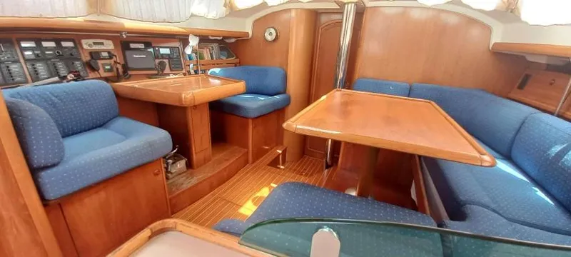 Happy Destiny Yacht Photos Pics Interior of 2004 Jeanneau Sun Odyssey 43 DS sailboat with blue seating and wooden finishes.