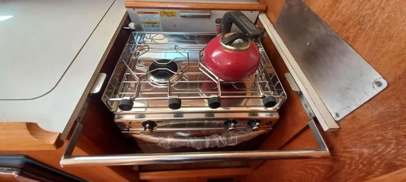 Happy Destiny Yacht Photos Pics Compact kitchen stove with red kettle on Jeanneau Sun Odyssey 43 DS, 2004 model.