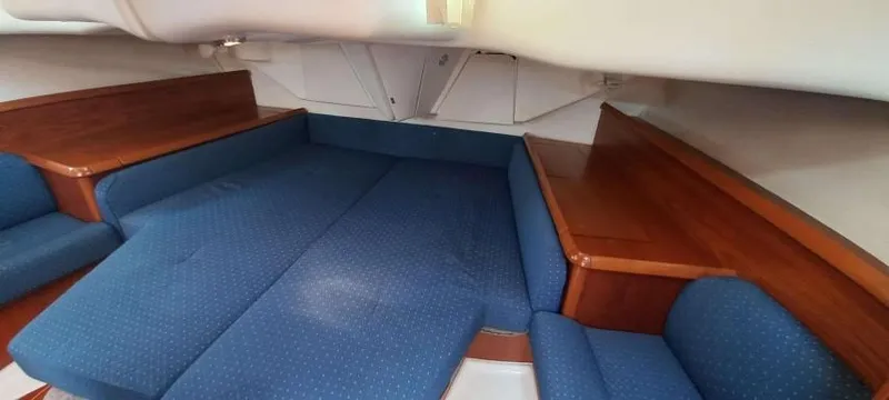 Happy Destiny Yacht Photos Pics Interior cabin of 2004 Jeanneau Sun Odyssey 43 DS with blue upholstery and wooden accents.