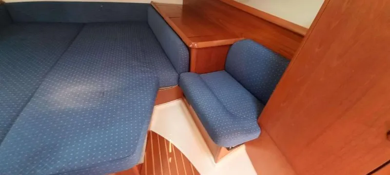 Happy Destiny Yacht Photos Pics Interior cabin of 2004 Jeanneau Sun Odyssey 43 DS with blue upholstery and wooden finish.