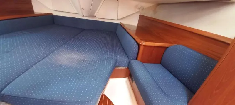 Happy Destiny Yacht Photos Pics 2004 Jeanneau Sun Odyssey 43 DS cabin with blue upholstery and wooden accents.