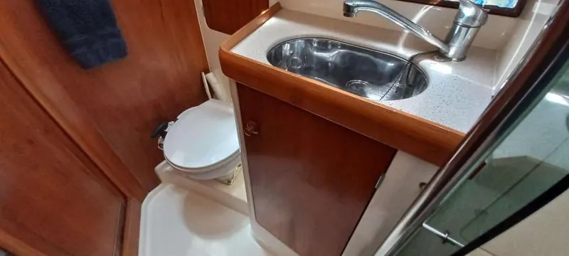 Happy Destiny Yacht Photos Pics Bathroom interior of 2004 Jeanneau Sun Odyssey 43 DS yacht, featuring sink and toilet.
