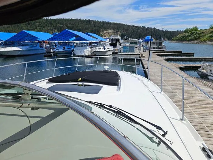  Yacht Photos Pics 2006 Sea Ray 44 Sundancer docked at marina with blue canopies and scenic background.