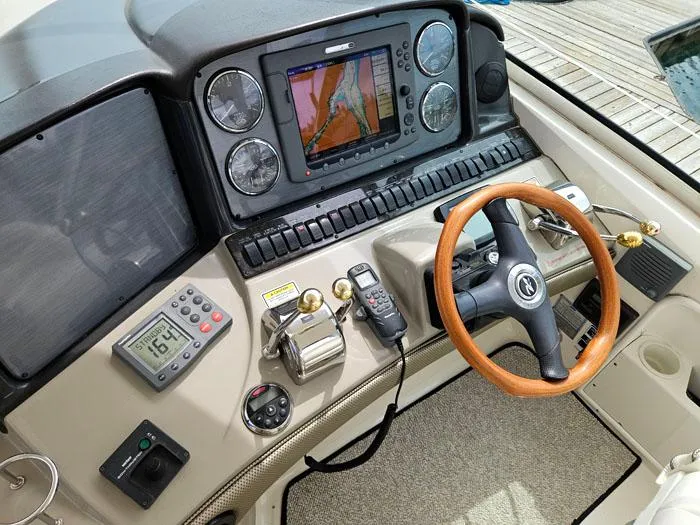 Yacht Photos Pics 2006 Sea Ray 44 Sundancer helm with navigation system and wooden steering wheel.