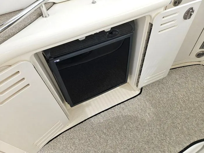  Yacht Photos Pics 2006 Sea Ray 44 Sundancer interior with built-in mini fridge and carpeted flooring.