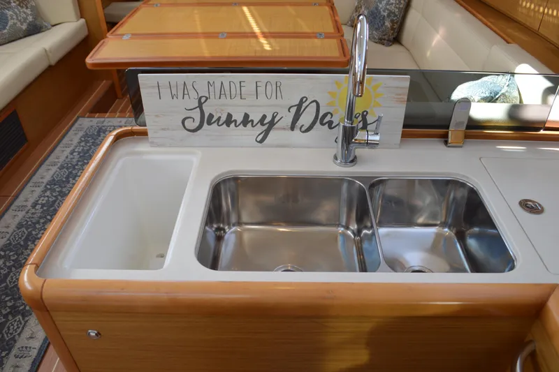 Down Time Yacht Photos Pics Galley sink area in 2008 Jeanneau Sun Odyssey 45 DS yacht with decorative sign.