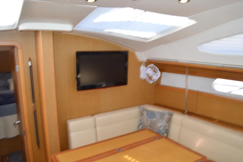 Down Time Yacht Photos Pics Interior of 2008 Jeanneau Sun Odyssey 45 DS yacht with seating, table, and TV.