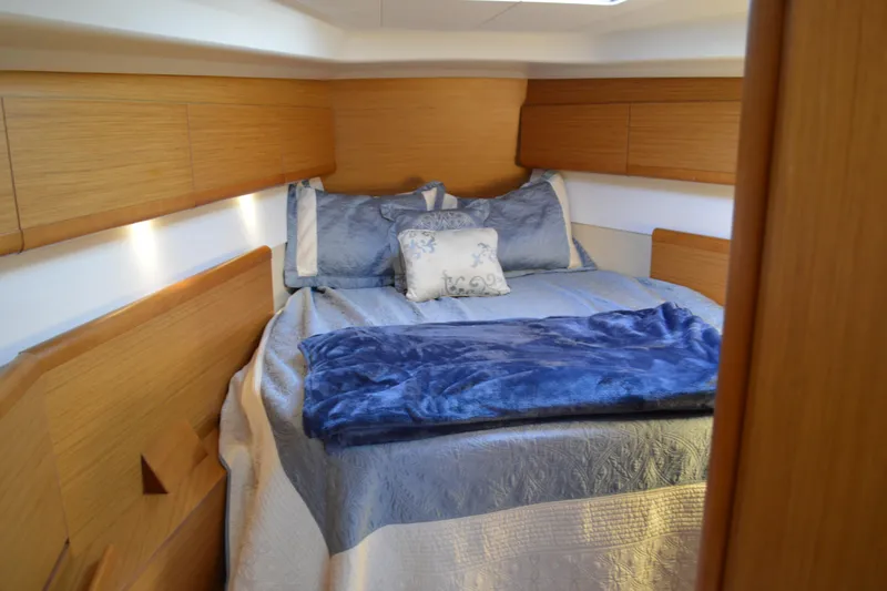 Down Time Yacht Photos Pics Cozy cabin interior of 2008 Jeanneau Sun Odyssey 45 DS with blue bedding.