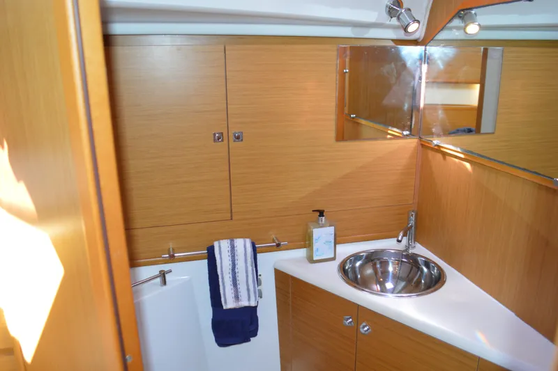 Down Time Yacht Photos Pics Luxurious bathroom in 2008 Jeanneau Sun Odyssey 45 DS yacht with wood cabinetry and stainless steel sink.