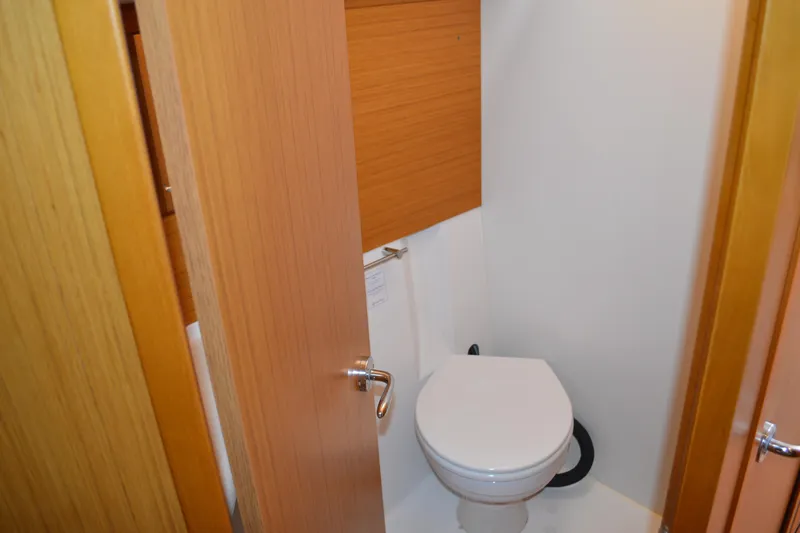 Down Time Yacht Photos Pics 2008 Jeanneau Sun Odyssey 45 DS yacht bathroom with wooden door and white toilet.