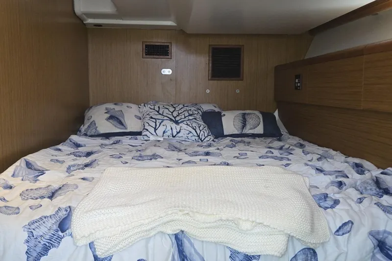 Down Time Yacht Photos Pics Cozy cabin interior of 2008 Jeanneau Sun Odyssey 45 DS with nautical-themed bedding.