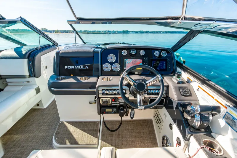 Good Morning Sunshine Yacht Photos Pics 2019 Formula 330 Crossover Bowrider cockpit with modern controls and steering wheel on a sunny day.
