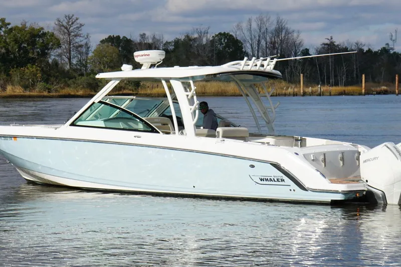  Yacht Photos Pics 2021 Boston Whaler 320 Vantage boat on calm water, featuring sleek design and twin engines.