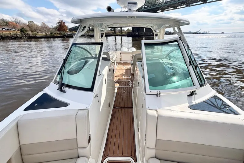  Yacht Photos Pics 2021 Boston Whaler 320 Vantage boat on calm water under a bridge.