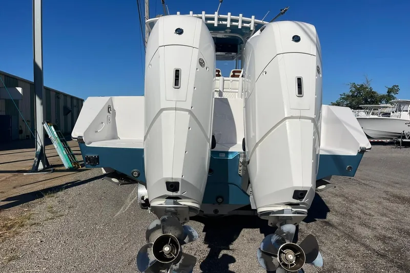  Yacht Photos Pics 2023 Jupiter 40 boat with dual outboard engines, parked on gravel under clear blue sky.