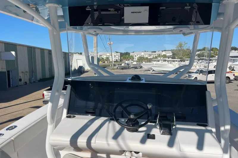  Yacht Photos Pics 2023 Jupiter 40 boat helm with steering wheel and control panel in marina setting.