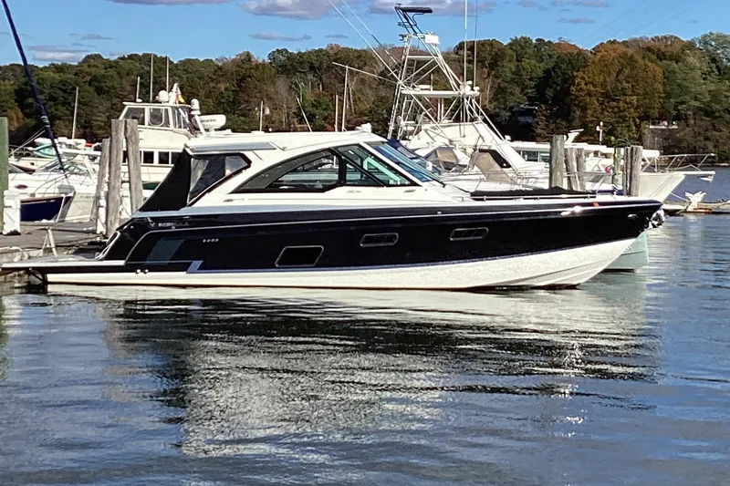 Steal Yacht Photos Pics 2020 Formula 380 Super Sport Crossover I/O docked in a marina, surrounded by other boats.