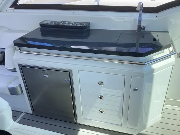 Steal Yacht Photos Pics 2020 Formula 380 Super Sport Crossover yacht kitchenette with sink, storage, and mini-fridge.