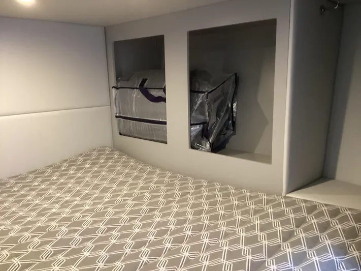 Steal Yacht Photos Pics 2020 Formula 380 Super Sport Crossover cabin with patterned bedding and storage compartments.