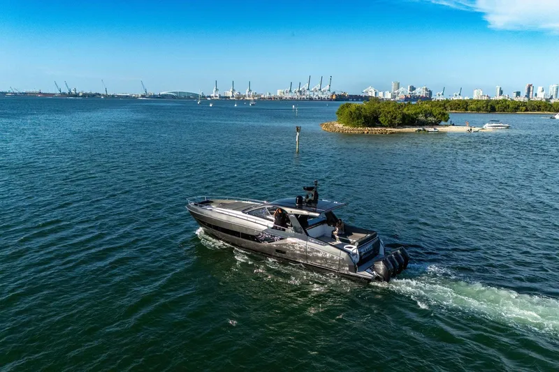 Matzu Yacht Photos Pics 2023 Azimut Verve 47 yacht cruising near a city skyline and small island.