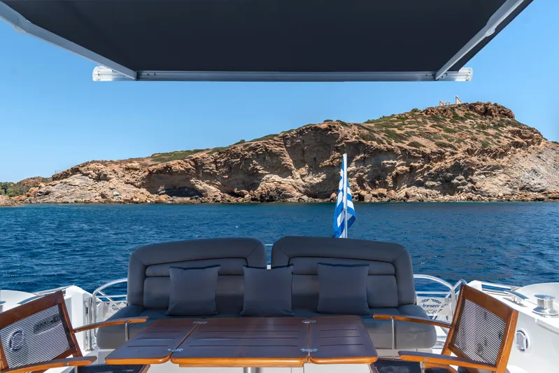 M/y Seaduced Yacht Photos Pics Sunseeker Predator 52 yacht, 2009 model, with scenic ocean and rocky coastline view.