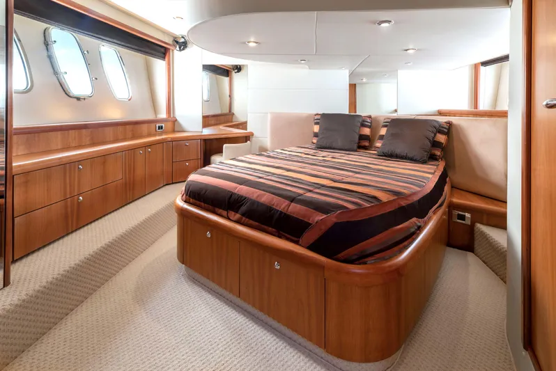 M/y Seaduced Yacht Photos Pics Luxurious 2009 Sunseeker Predator 52 yacht bedroom with elegant wood finishes and striped bedding.