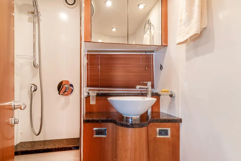 M/y Seaduced Yacht Photos Pics Luxurious bathroom in 2009 Sunseeker Predator 52 yacht with modern fixtures and wooden accents.