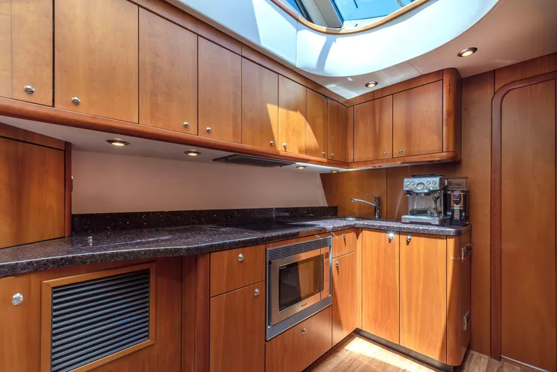 M/y Seaduced Yacht Photos Pics Luxurious wooden kitchen interior of 2009 Sunseeker Predator 52 yacht with modern appliances.
