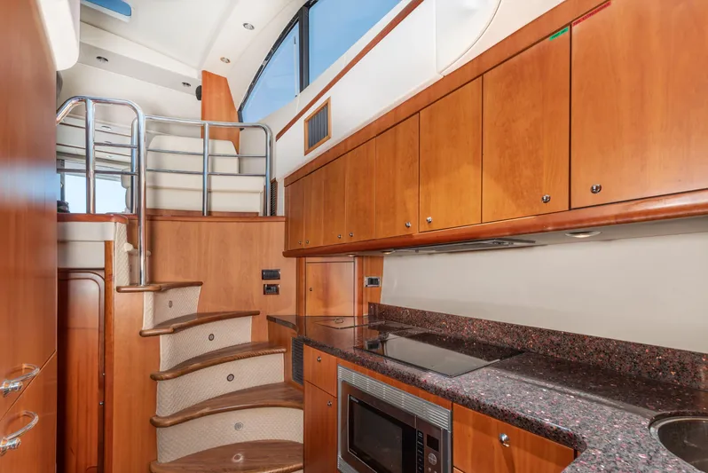 M/y Seaduced Yacht Photos Pics Luxurious 2009 Sunseeker Predator 52 yacht interior with modern kitchen and wooden cabinetry.