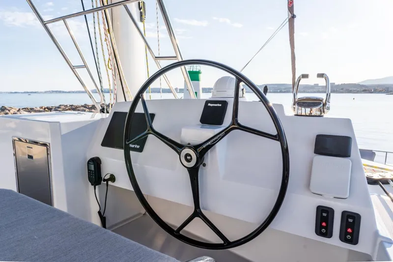 Signature Bali 5.4. (5+2 Cabins) Yacht Photos Pics Steering wheel of a 2021 Bali 5.4 catamaran, overlooking a serene ocean view.
