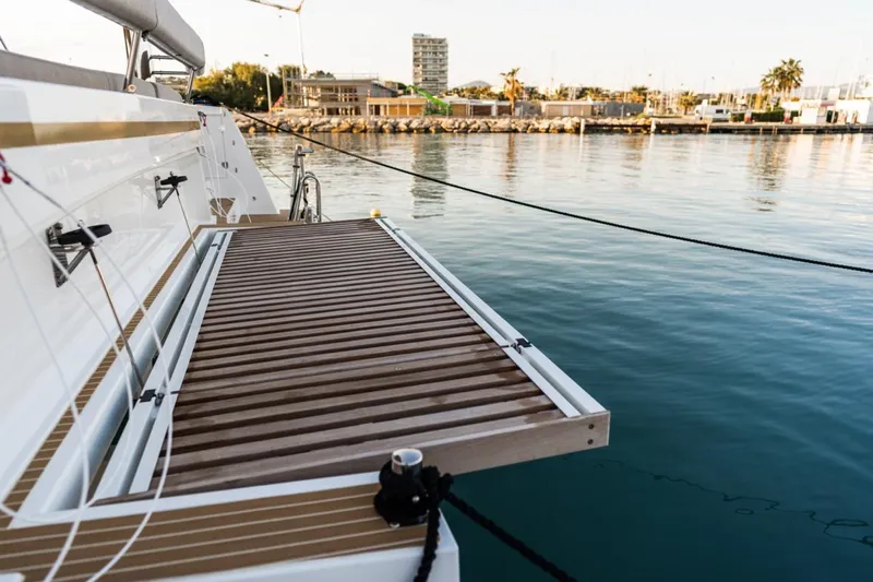 Signature Bali 5.4. (5+2 Cabins) Yacht Photos Pics Bali 5.4 yacht deck with wooden platform, docked in a serene marina, 2021 model.