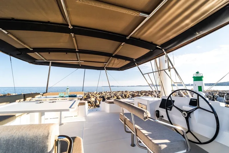 Signature Bali 5.4. (5+2 Cabins) Yacht Photos Pics Luxurious Bali 5.4 catamaran deck with steering wheel, ocean view, and lighthouse in 2021.