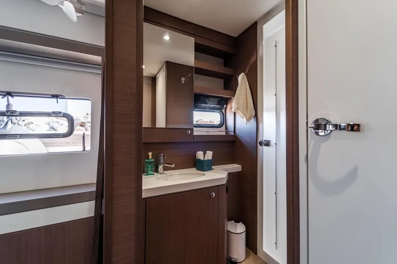 Signature Bali 5.4. (5+2 Cabins) Yacht Photos Pics Modern bathroom interior on a 2021 Bali 5.4 yacht, featuring sleek wood cabinetry and a window.