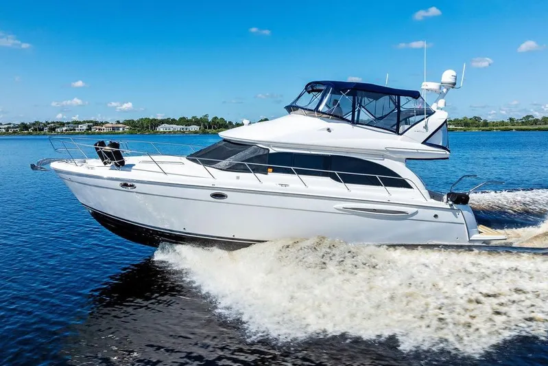  Yacht Photos Pics 2008 Meridian 411 Sedan cruising on a sunny day, creating waves in calm waters.