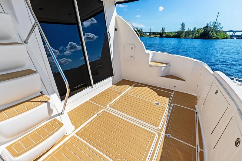  Yacht Photos Pics 2008 Meridian 411 Sedan yacht deck with wooden flooring, overlooking serene blue water.