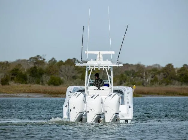  Yacht Photos Pics 2025 Yellowfin 34 Offshore boat with triple engines cruising on a calm waterway.