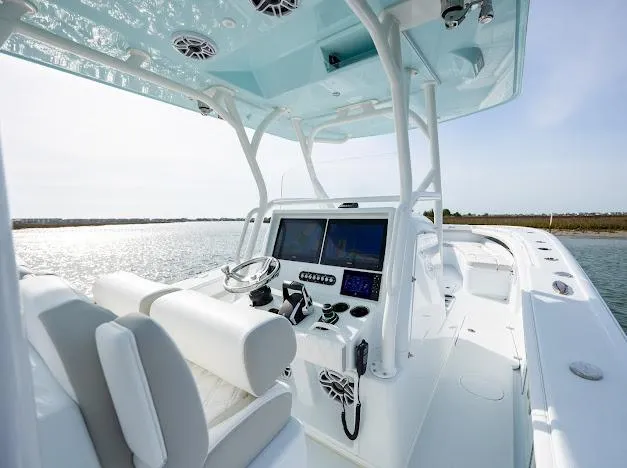  Yacht Photos Pics 2025 Yellowfin 34 Offshore boat interior with modern controls and seating, on calm water.