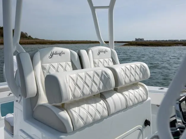  Yacht Photos Pics 2025 Yellowfin 34 Offshore boat with luxurious white seating on a calm water backdrop.