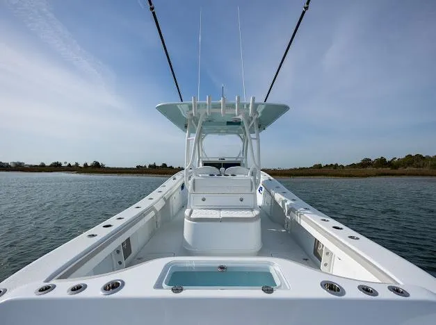  Yacht Photos Pics 2025 Yellowfin 34 Offshore boat on calm water, showcasing sleek design and spacious deck.