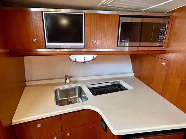 2006 Tiara 3600 Open @ Cancun Yacht Photos Pics 2006 Tiara Yachts 3600 Open galley with sink, stove, microwave, and TV.