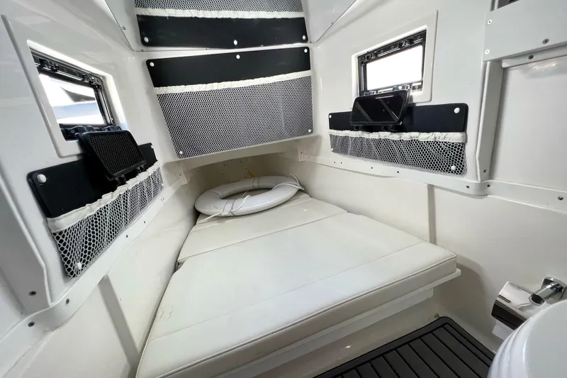 Sunset Chaser Yacht Photos Pics 2023 Tidewater 320 CC Adventure cabin interior with cushioned seating and storage nets.