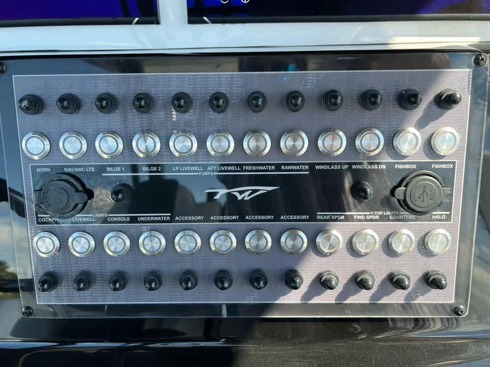 Sunset Chaser Yacht Photos Pics Control panel of 2023 Tidewater 320 CC Adventure boat with labeled switches and buttons.