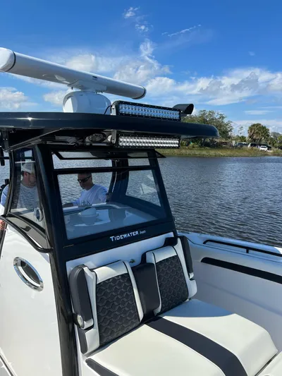 Sunset Chaser Yacht Photos Pics 2023 Tidewater 320 CC Adventure boat on a calm lake under a clear blue sky.