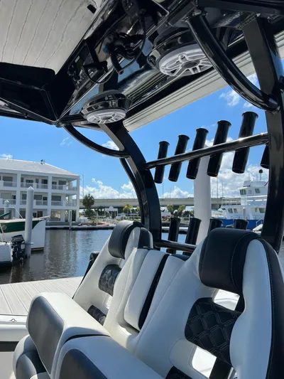 Sunset Chaser Yacht Photos Pics 2023 Tidewater 320 CC Adventure boat interior with rod holders and seating at marina.