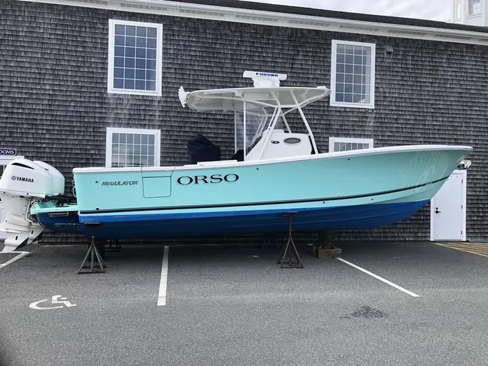 One Knot Yacht Photos Pics 2018 Regulator 31 boat on stands, parked near a building.