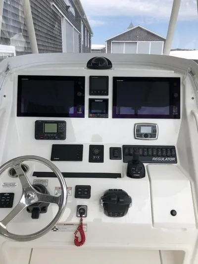 One Knot Yacht Photos Pics 2018 Regulator 31 boat dashboard with dual screens and navigation controls.