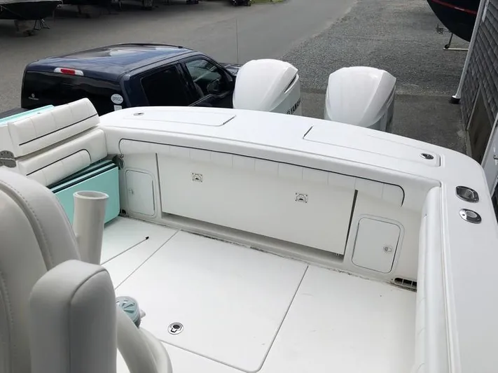 One Knot Yacht Photos Pics 2018 Regulator 31 boat with dual outboard engines, spacious deck, and seating area.