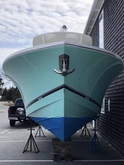 One Knot Yacht Photos Pics 2018 Regulator 31 boat on stands, parked beside a building.