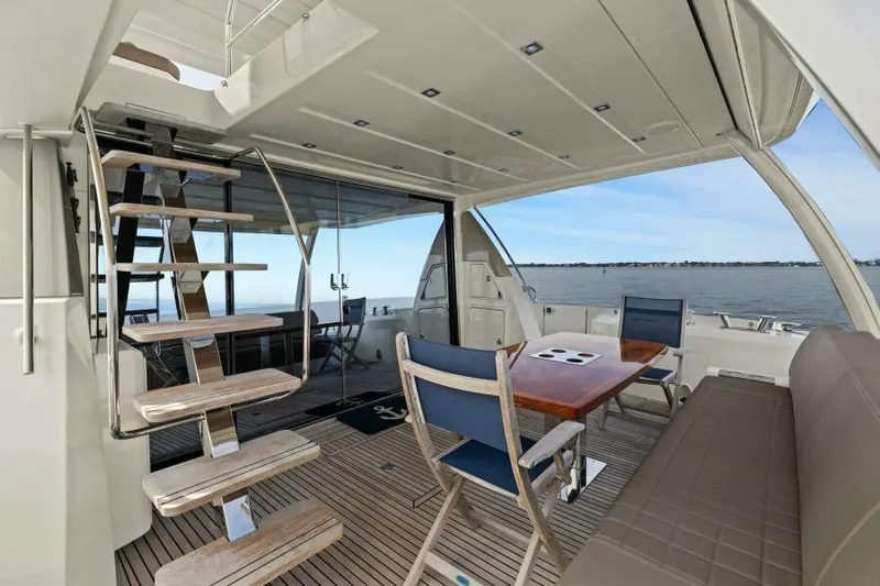 Be As You Are Xl Yacht Photos Pics Prestige 680 Flybridge 2017 yacht interior with seating, table, and stairs, overlooking the ocean.